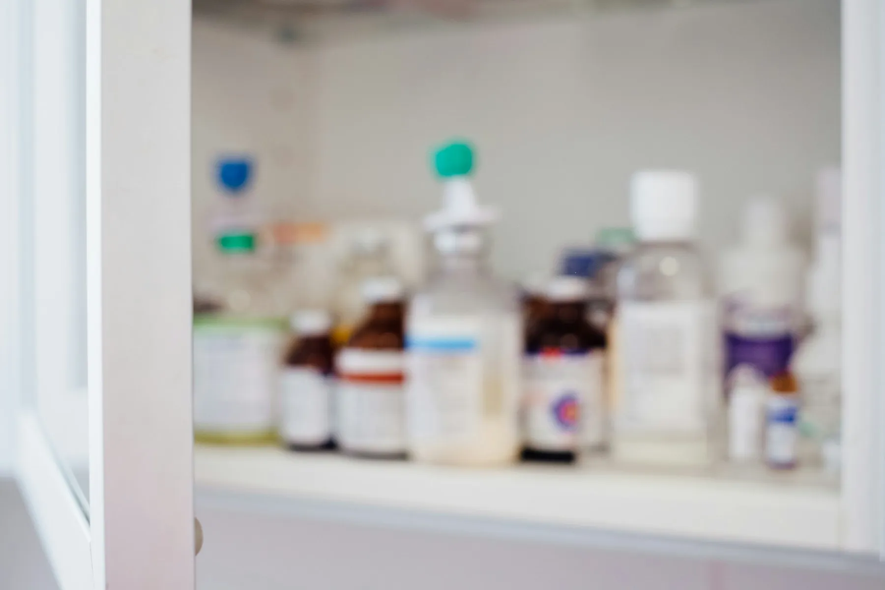 Flacons de pharmacie à étiquettes blanches et rouges alignés